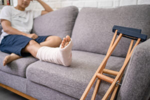 Young man who has been injured sitting on the couch.