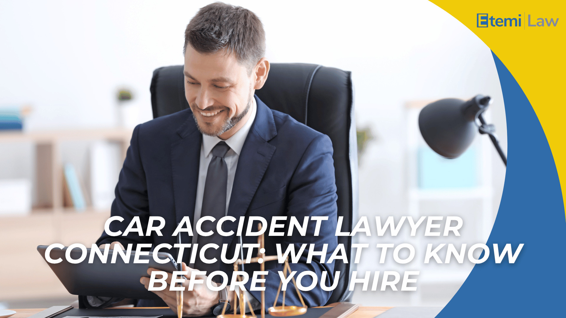Attorney in suit using tablet at desk with scales of justice introducing hiring a car accident lawyer